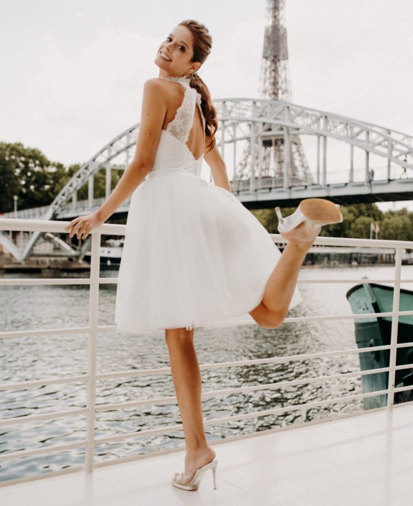 femme dans une robe de mariée courte en dentelle devant la Seine à Paris