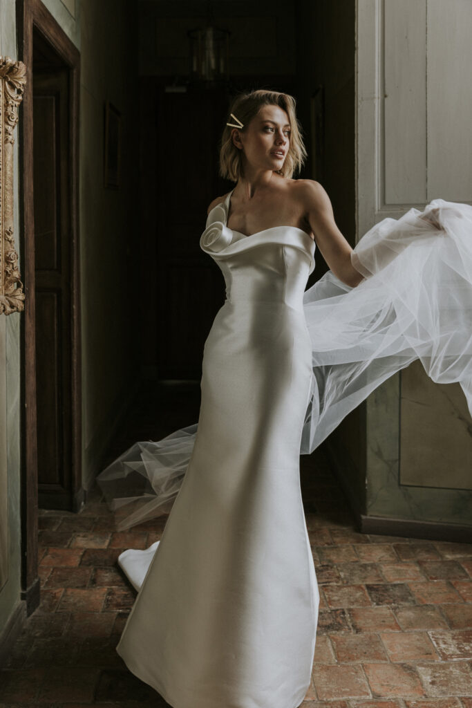 femme avec une robe de mariée glamour et épurée en mikado dans un château