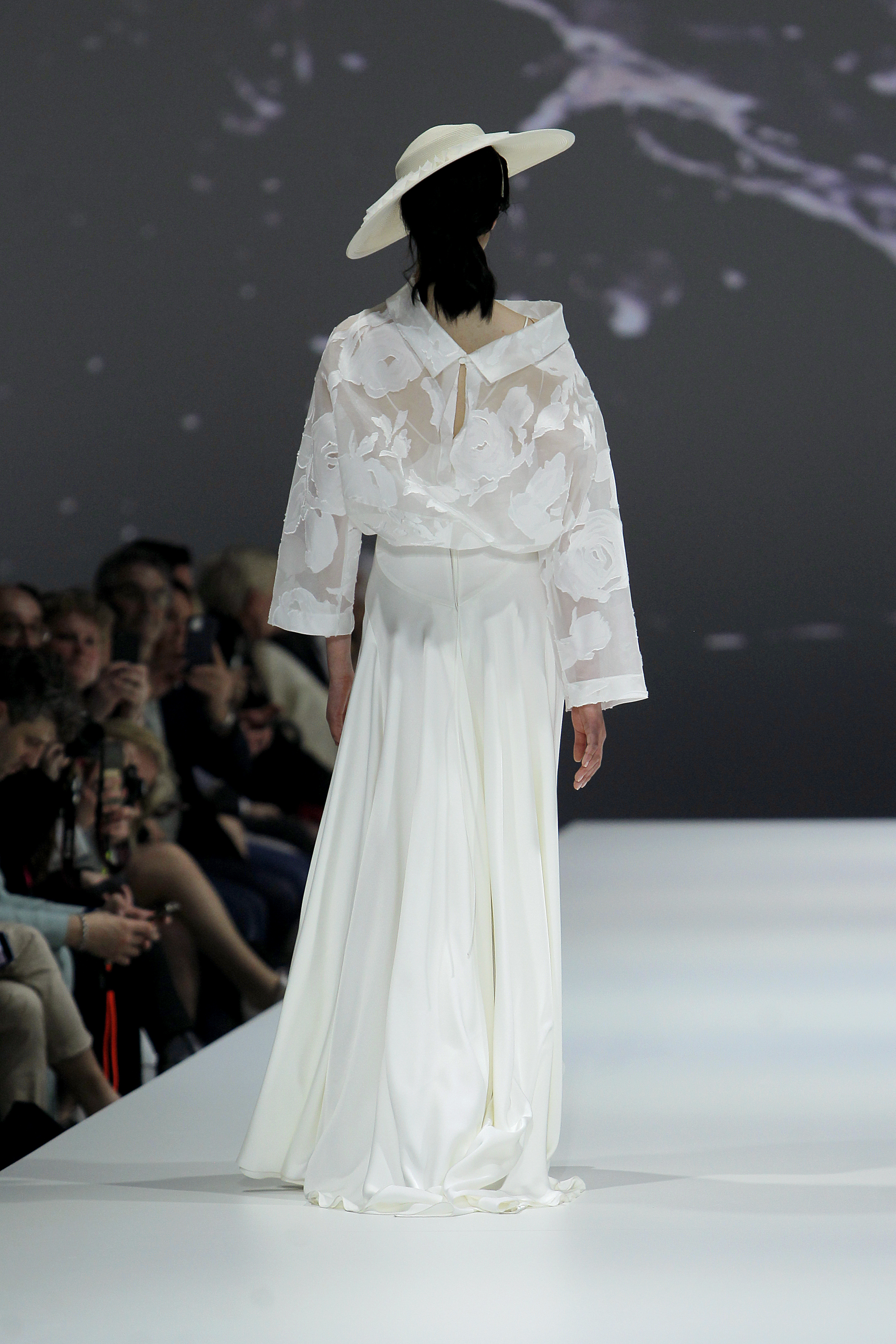 photo de dos d'une femme dans un show avec une robe blanche
