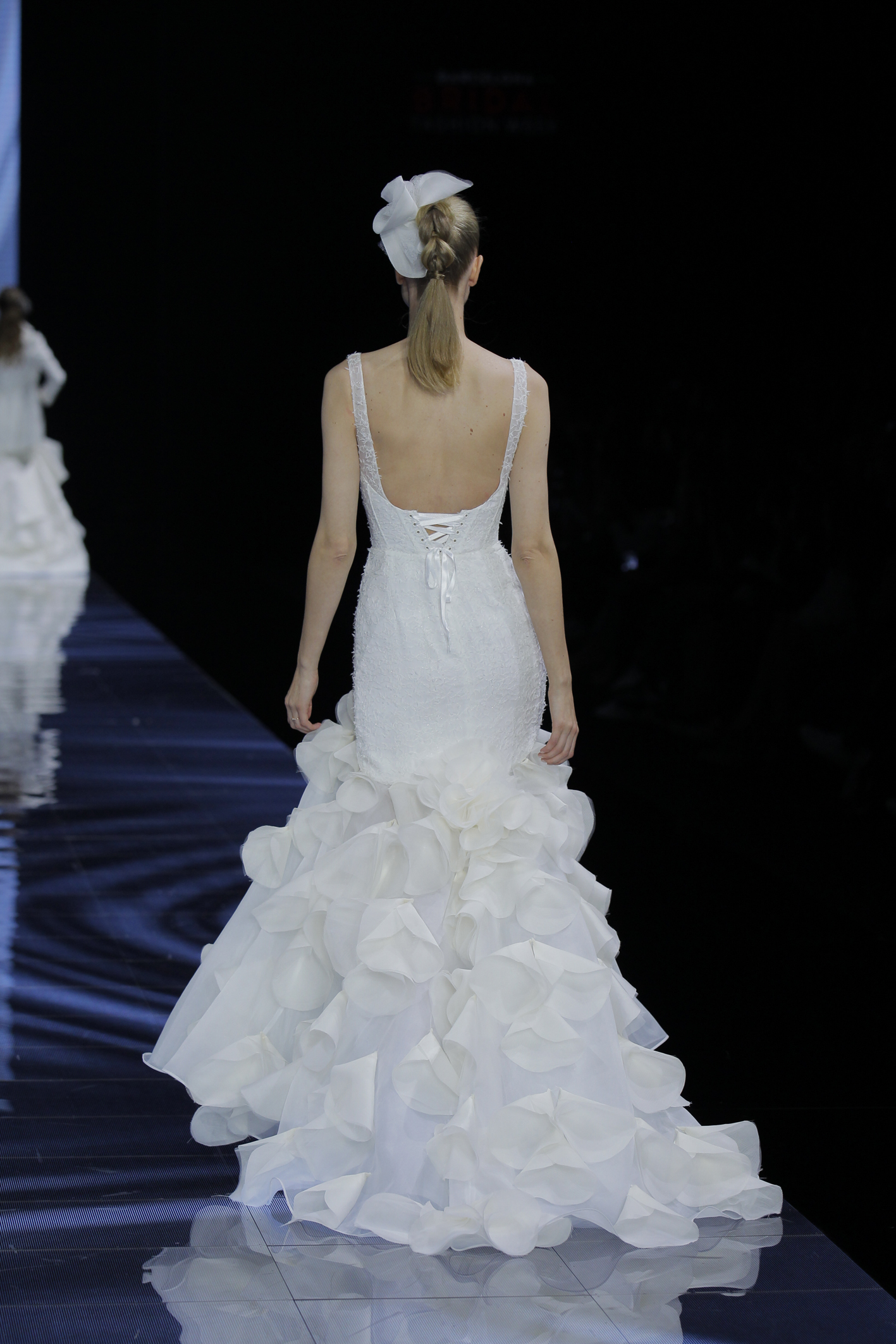 femme dans une robe de mariée sirène glamour à un défilé
