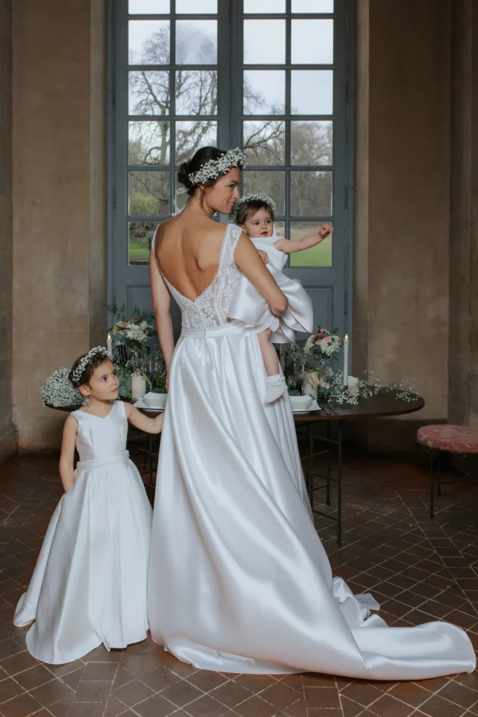 une maman en robe de mariée avec ses deux filles