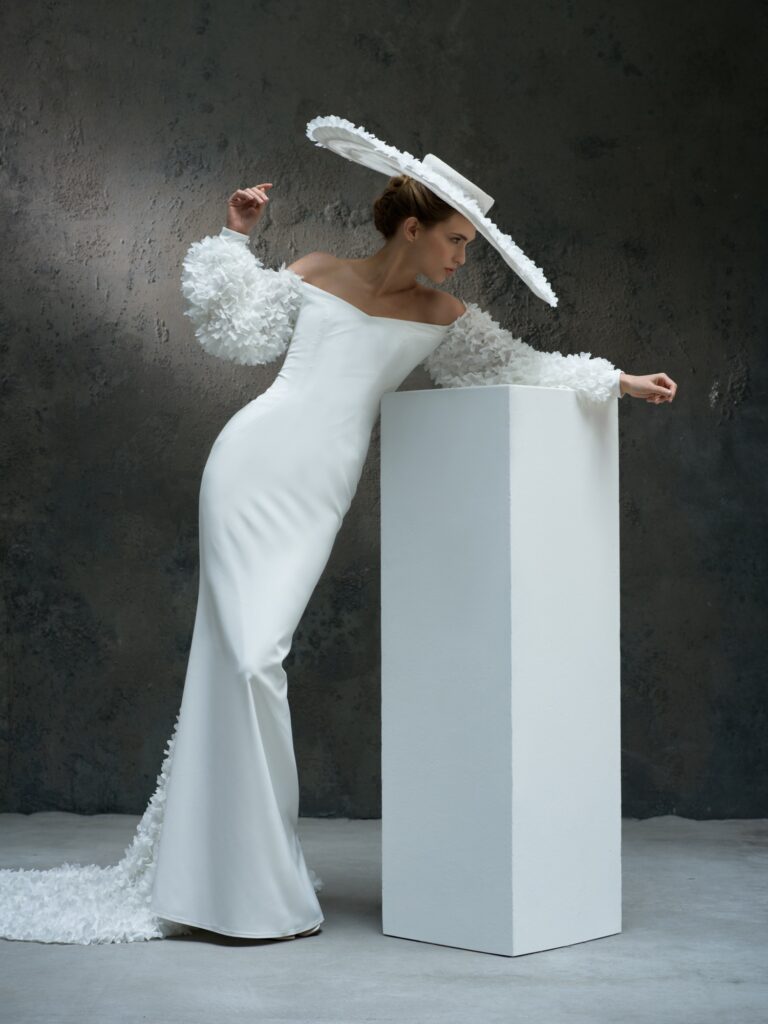 femme dans une robe de mariée fourreau sirène dans un studio