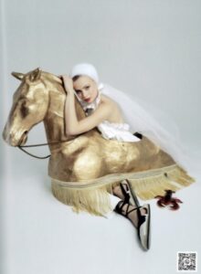 femme dans une robe de mariée et un voile avec un cheval en bronze