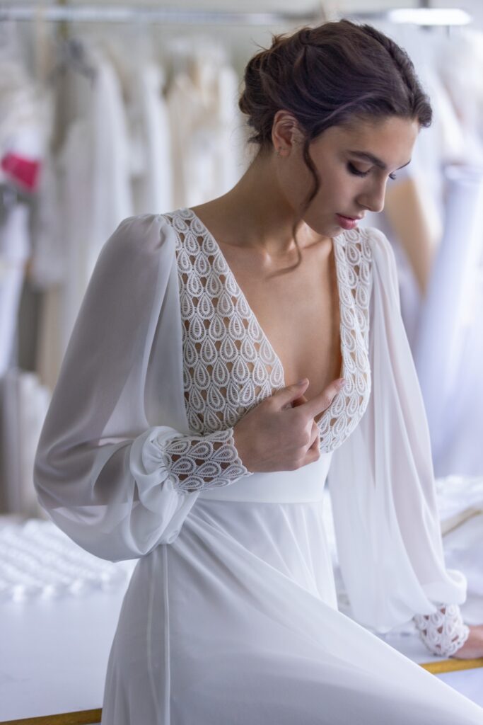 femme dans une robe de mariée de créateur bohème chic à manches longues