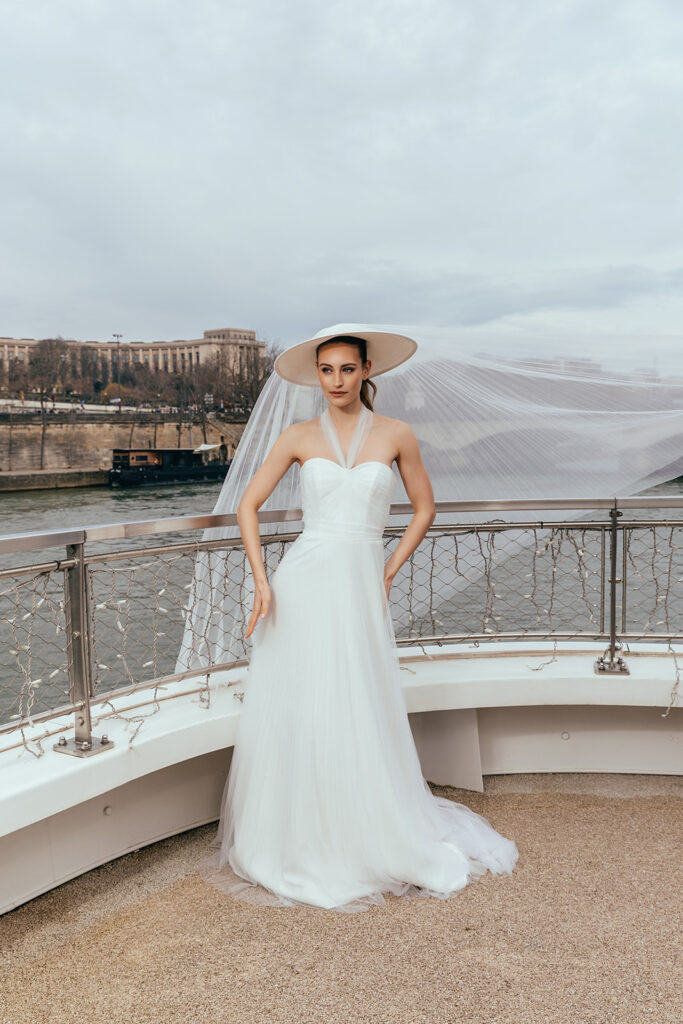 femme dans une robe de mariée glamour avec un chapeau à Paris