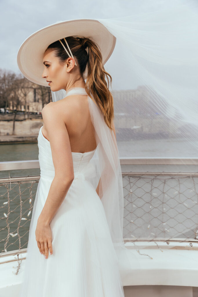 femme dans une robe de mariée glamour avec un chapeau à Paris