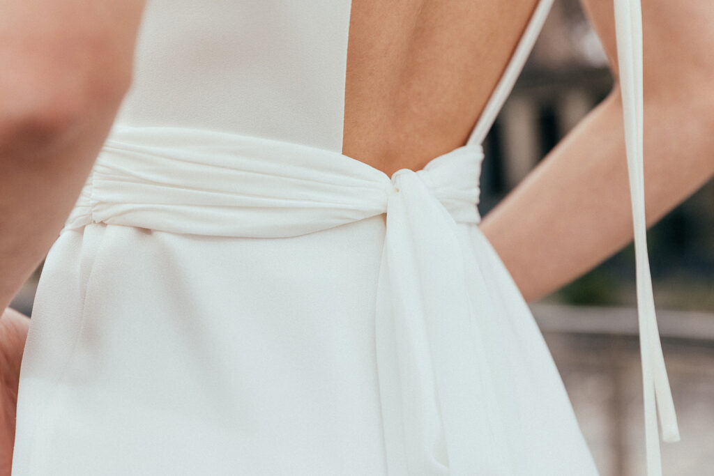 détail du dos de la ceinture de la robe de mariée portée par une femme