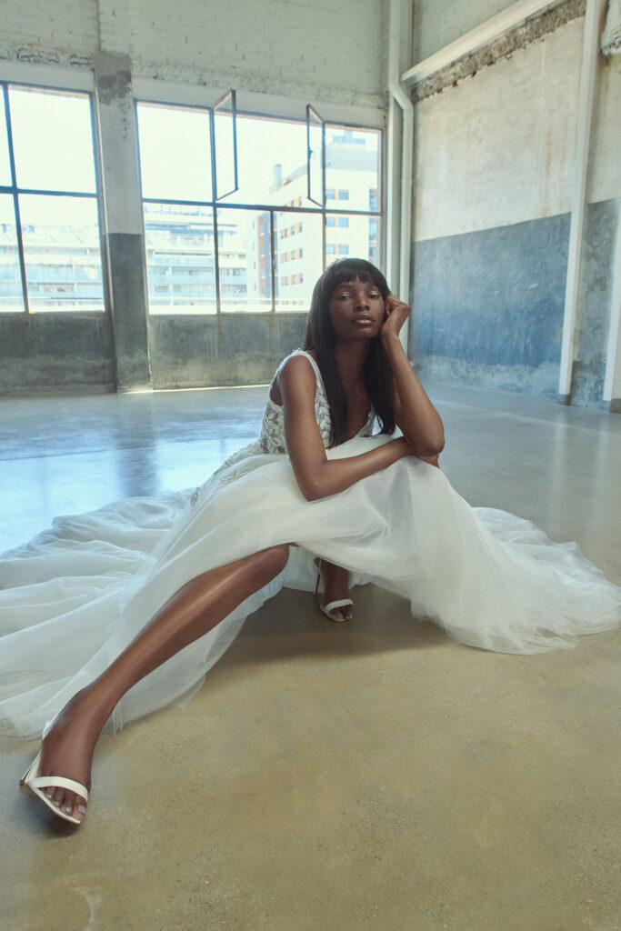femme accroupie habillée d'une robe de mariée sans manches glamour