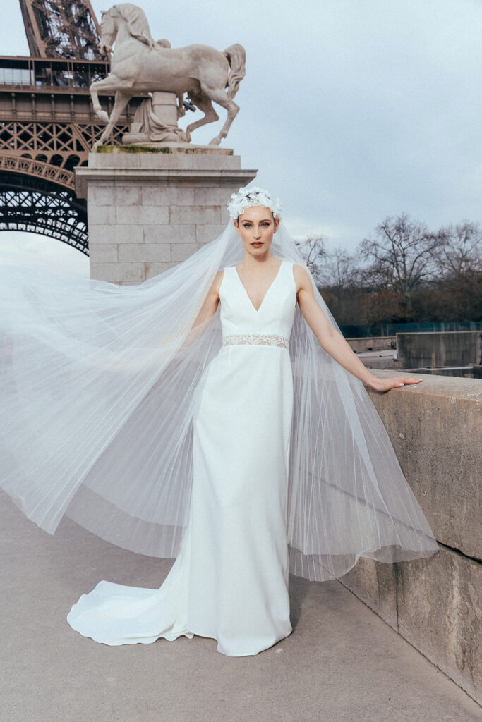 femme dans une robe de mariée sirène glamour avec un voile plissé à Paris