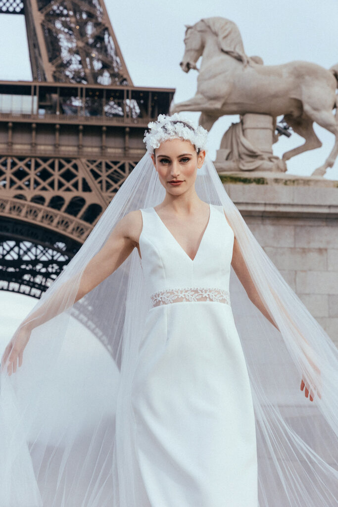 femme dans une robe de mariée sirène glamour avec un voile plissé à Paris