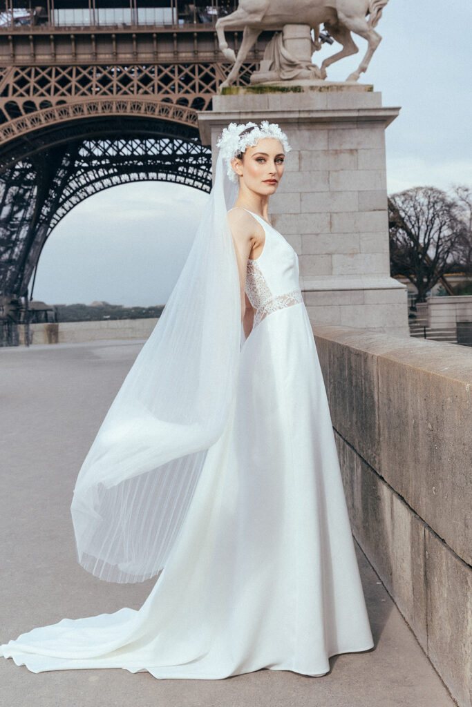 femme dans une robe de mariée sirène glamour avec un voile plissé à Paris