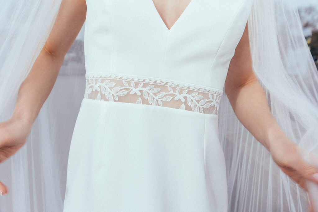 femme dans une robe de mariée sirène glamour avec un voile plissé à Paris