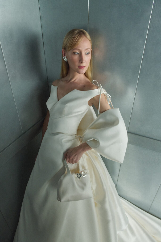 femme habillée d'une robe de mariée princesse originale et glamour avec un noeud à la taille dans lequel le bras passe