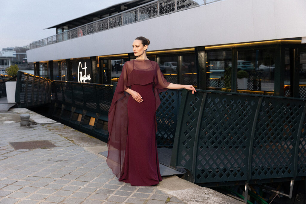 femme à Paris habillé d'une robe du soir sirène raffinée agrémentée d'une élégante cape transparente