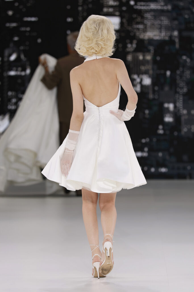 femme dans une robe de mariée à bretelles sur un podium de défilé