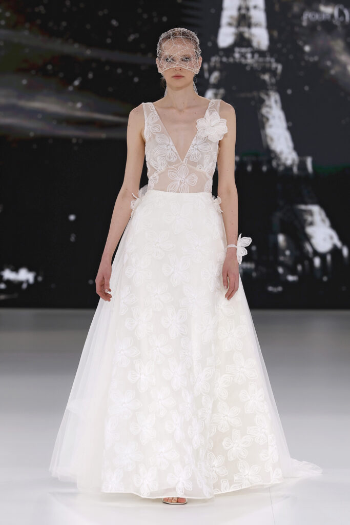 femme dans une robe de mariée à bretelles sur un podium de défilé
