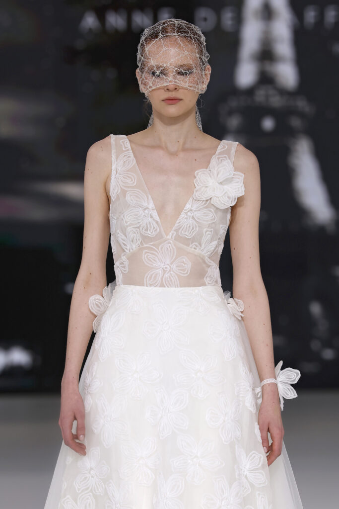 femme dans une robe de mariée à bretelles sur un podium de défilé