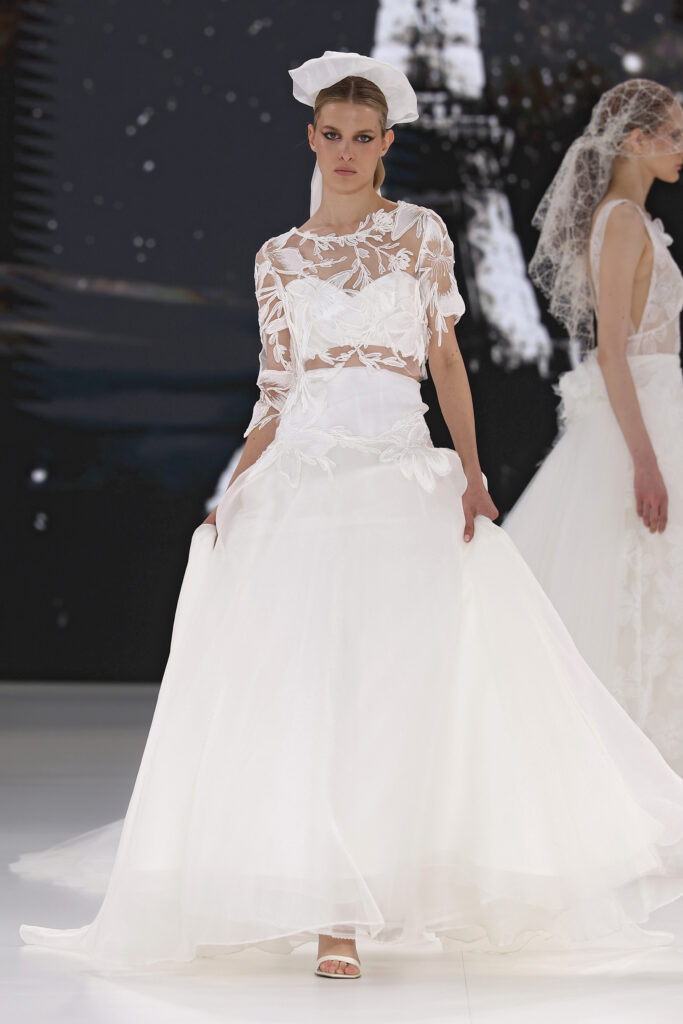 femme dans une robe de mariée avec un top en dentelle et une jupe sur un podium de défilé