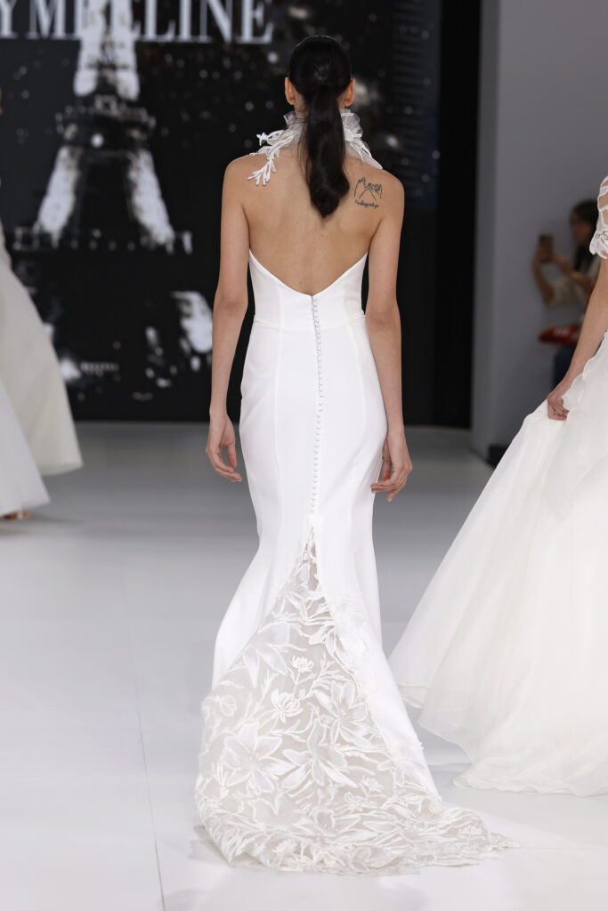 femme dans une robe de mariée sirène sur un podium de défilé
