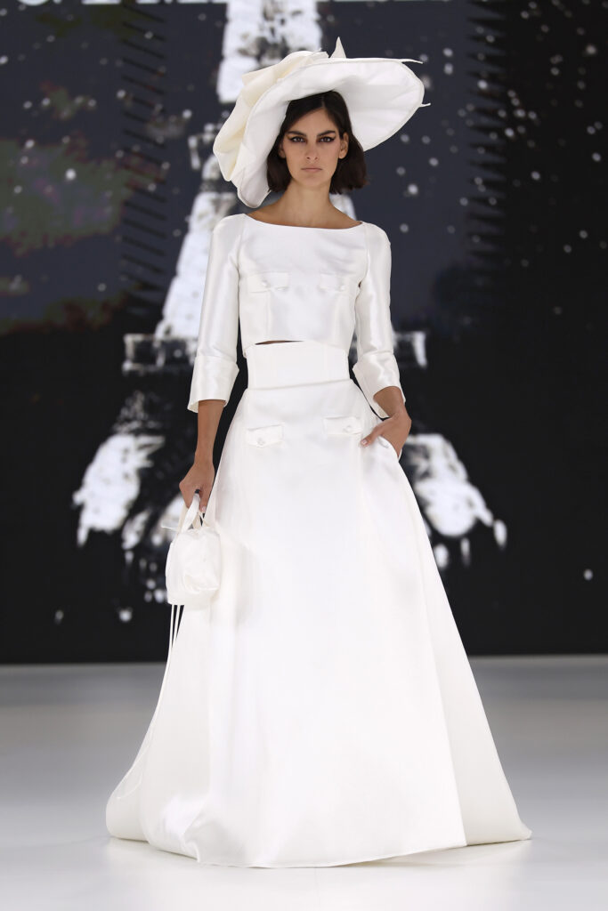 femme dans une robe de mariée avec un top et une jupe sur un podium de défilé