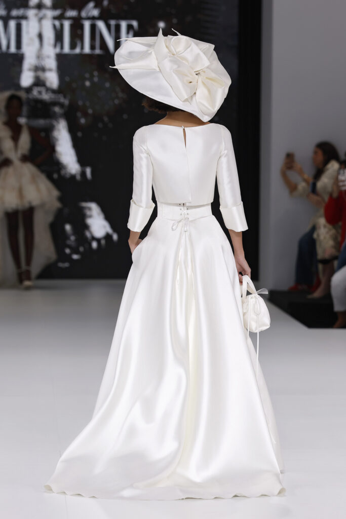 femme dans une robe de mariée avec un top et une jupe sur un podium de défilé