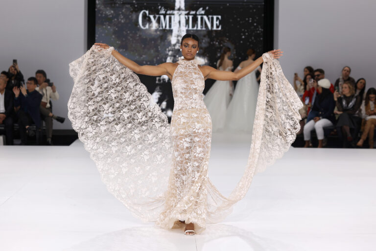 femme dans une robe de mariée sirène en dentelle sur un podium de défilé