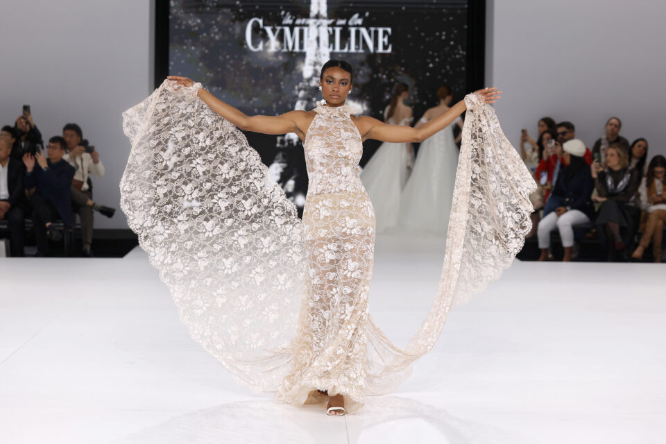 femme dans une robe de mariée sirène en dentelle sur un podium de défilé