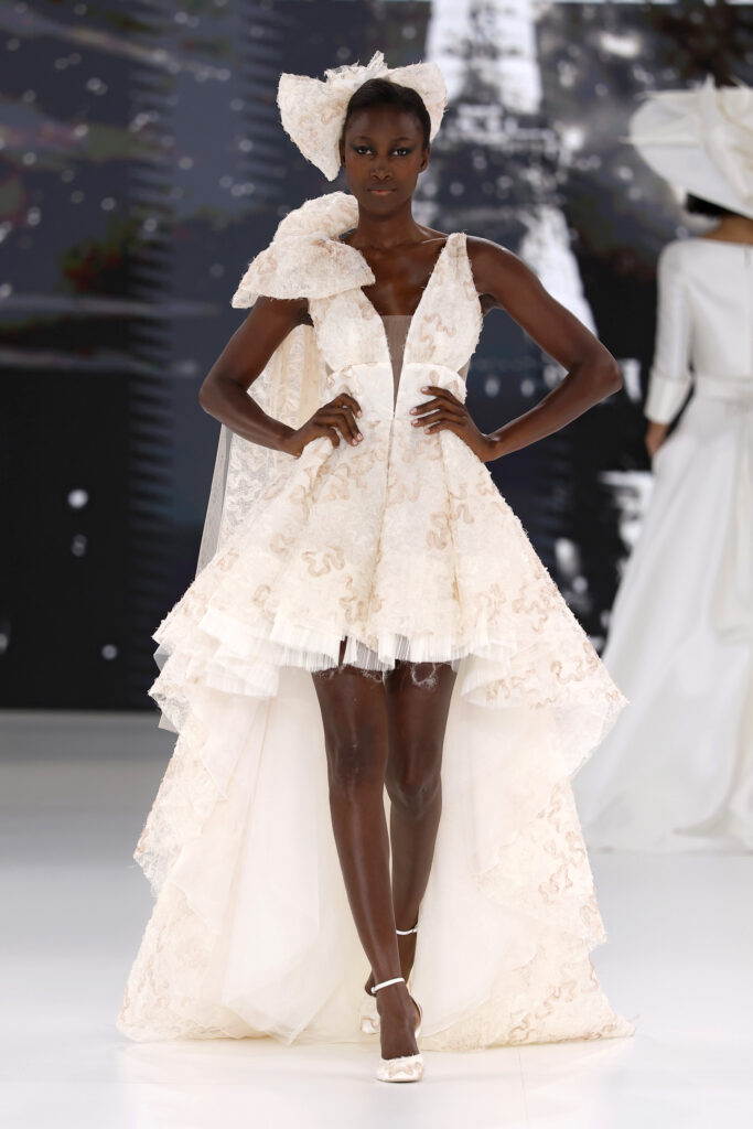 femme dans une robe de mariée originale en dentelle sur un podium de défilé