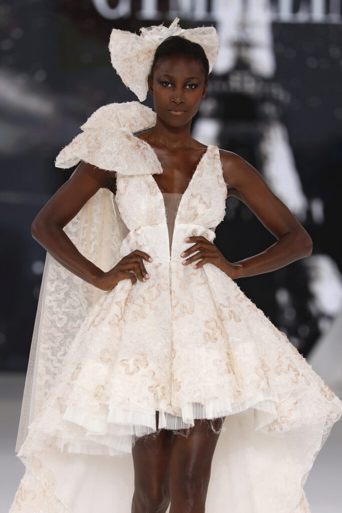 femme dans une robe de mariée originale en dentelle sur un podium de défilé