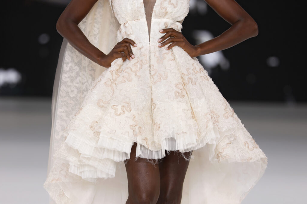 femme dans une robe de mariée originale en dentelle sur un podium de défilé