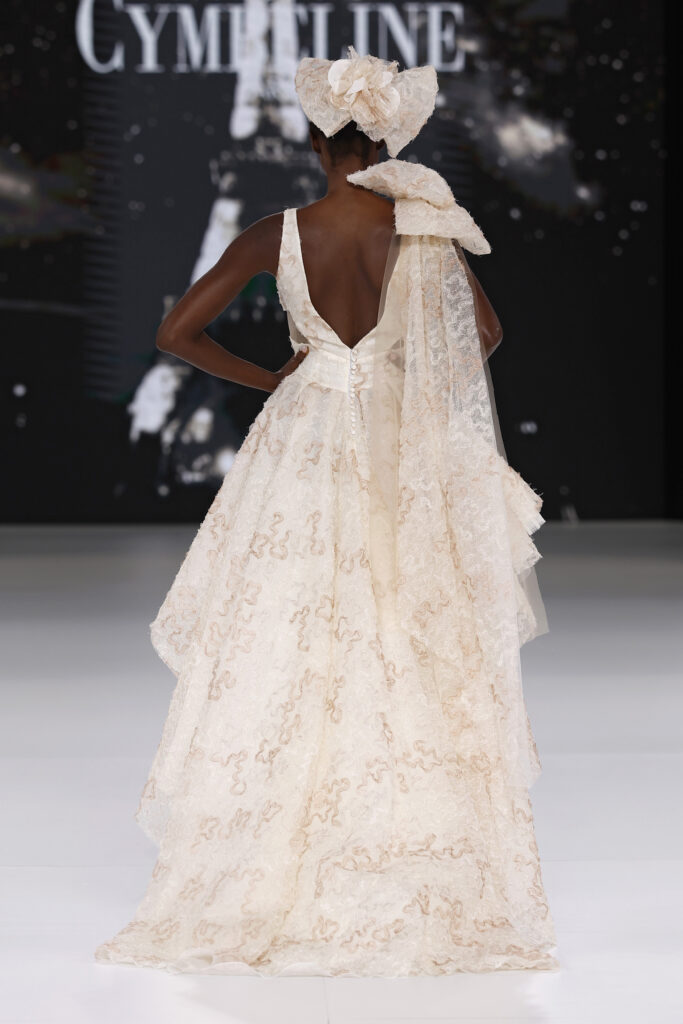 femme dans une robe de mariée originale en dentelle sur un podium de défilé
