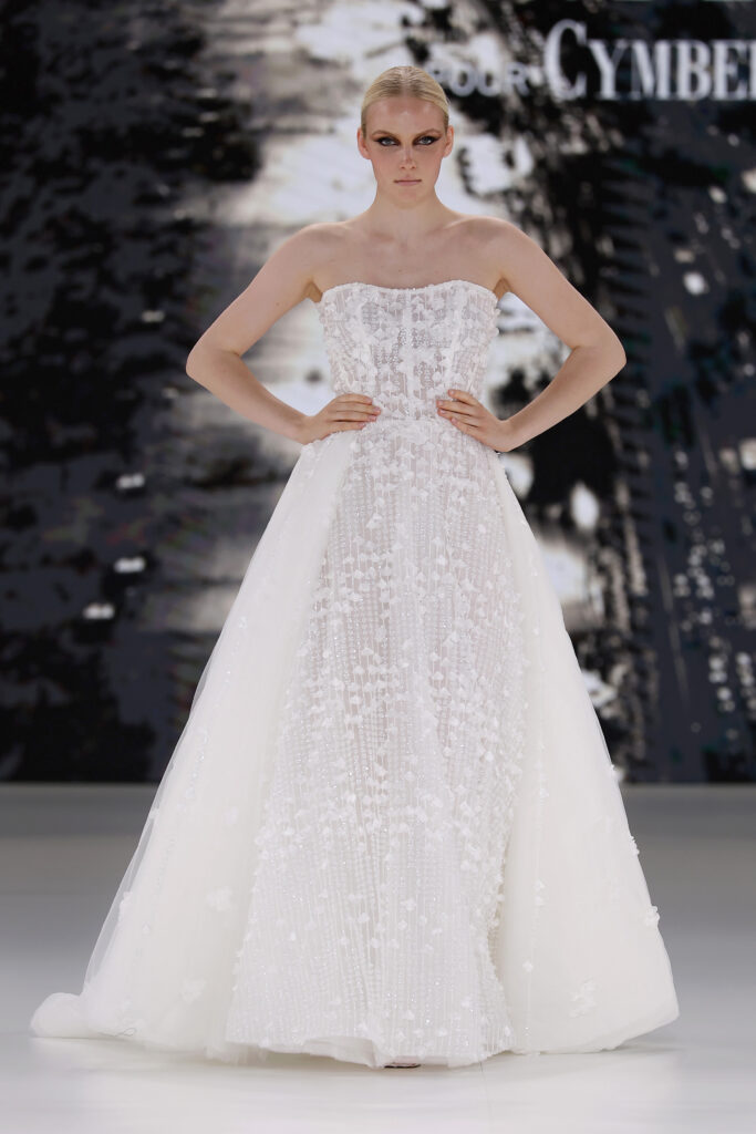 femme dans une robe de mariée princesse brillante en dentelle sur un podium de défilé
