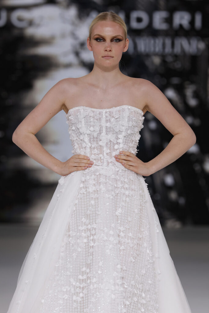 femme dans une robe de mariée princesse brillante en dentelle sur un podium de défilé