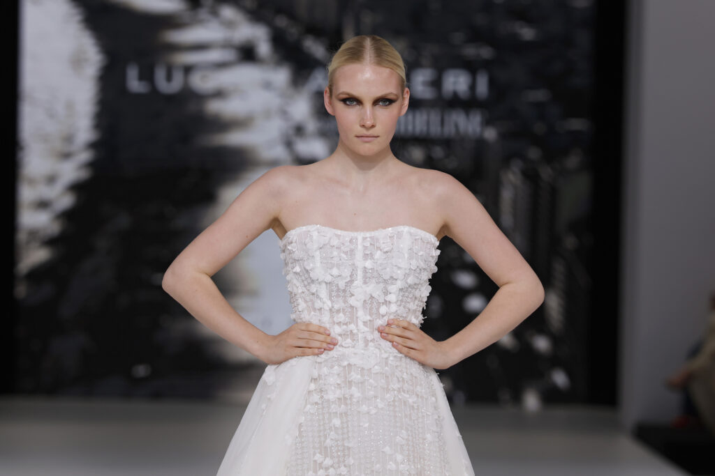 femme dans une robe de mariée princesse brillante en dentelle sur un podium de défilé