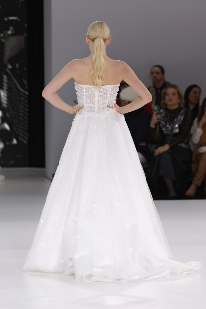 femme dans une robe de mariée princesse brillante en dentelle sur un podium de défilé