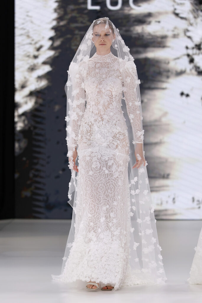 femme dans une robe de mariée sirène brillante en dentelle sur un podium de défilé