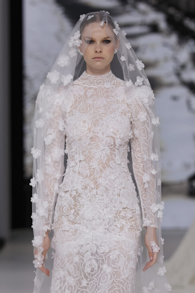 femme dans une robe de mariée sirène brillante en dentelle sur un podium de défilé