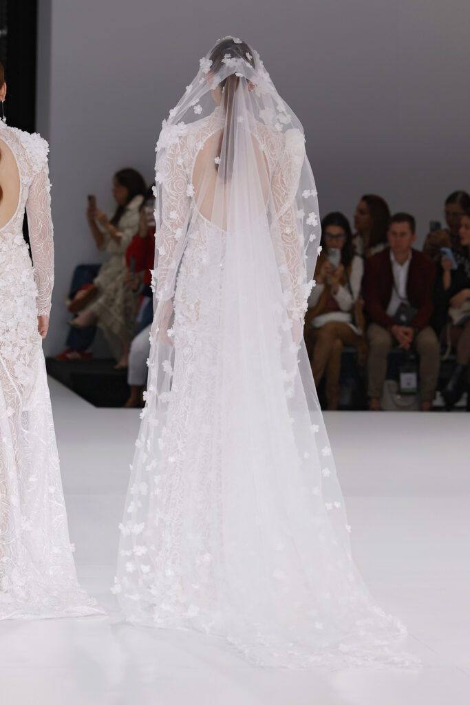 femme dans une robe de mariée sirène brillante en dentelle sur un podium de défilé