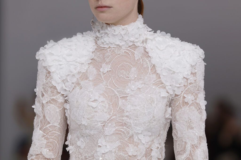 femme dans une robe de mariée sirène brillante en dentelle sur un podium de défilé