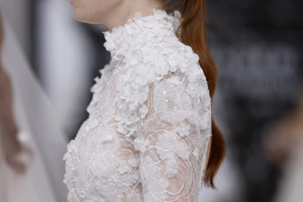 femme dans une robe de mariée sirène brillante en dentelle sur un podium de défilé