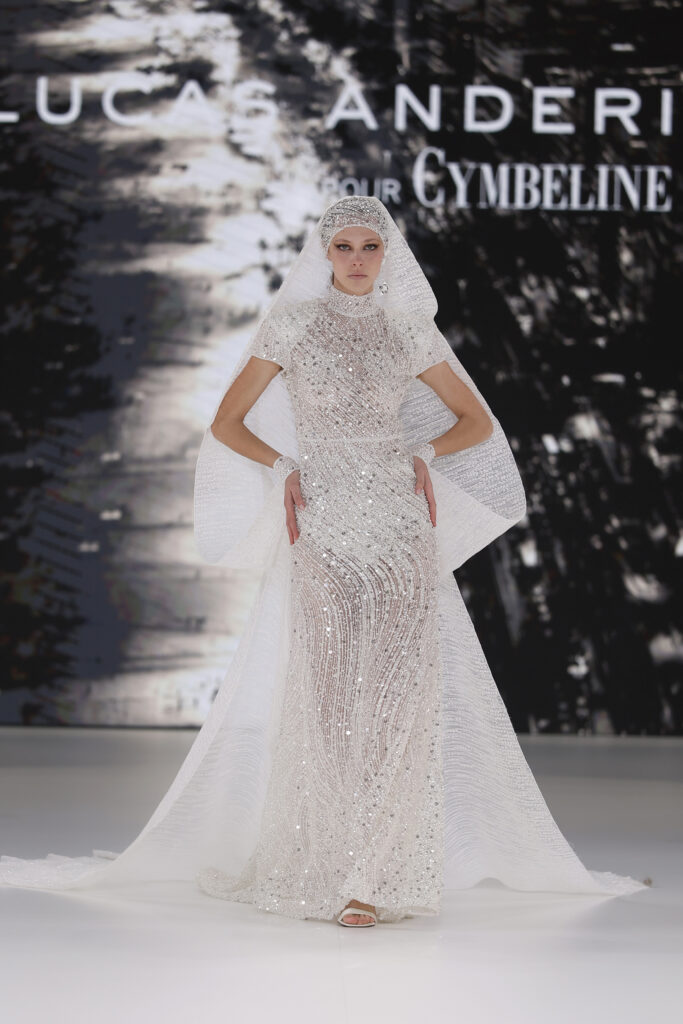 femme dans une robe de mariée sirène brillante en perles sur un podium de défilé