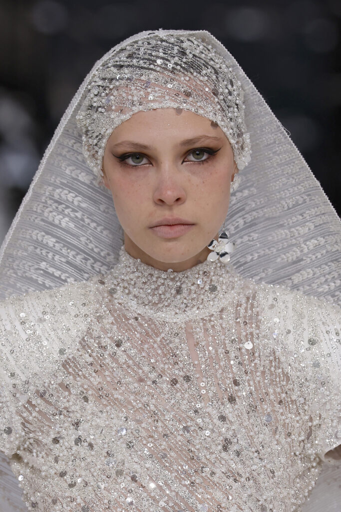 femme dans une robe de mariée sirène brillante en perles sur un podium de défilé