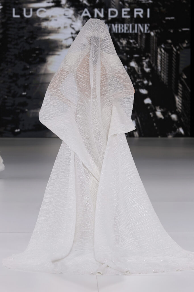 femme dans une robe de mariée sirène brillante en perles sur un podium de défilé