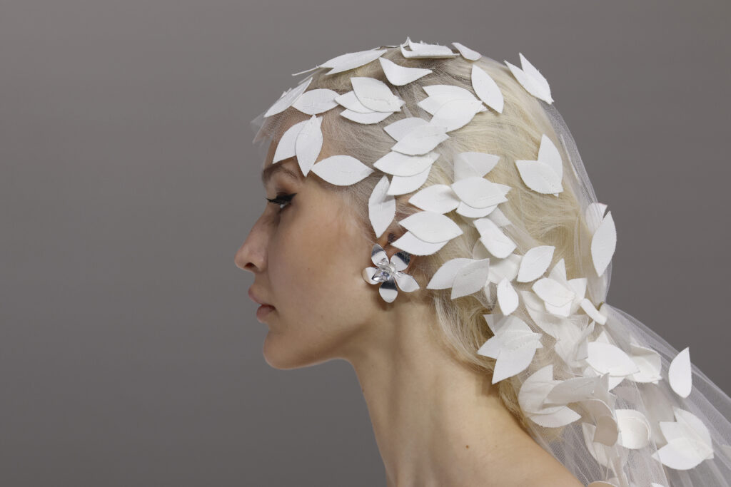 femme dans une robe de mariée princesse originale avec un long voile sur un podium de défilé