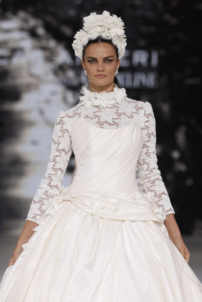 femme dans une robe de mariée princesse à manches longues en dentelle et en taffetas de soie sur un podium de défilé