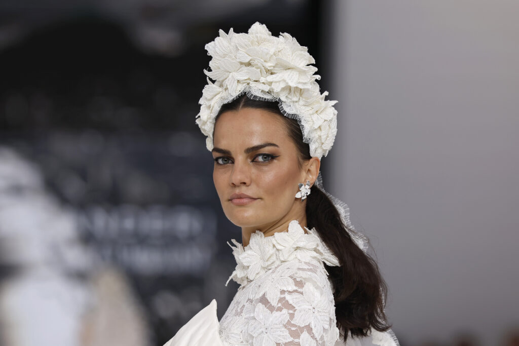 femme dans une robe de mariée princesse à manches longues en dentelle et en taffetas de soie sur un podium de défilé