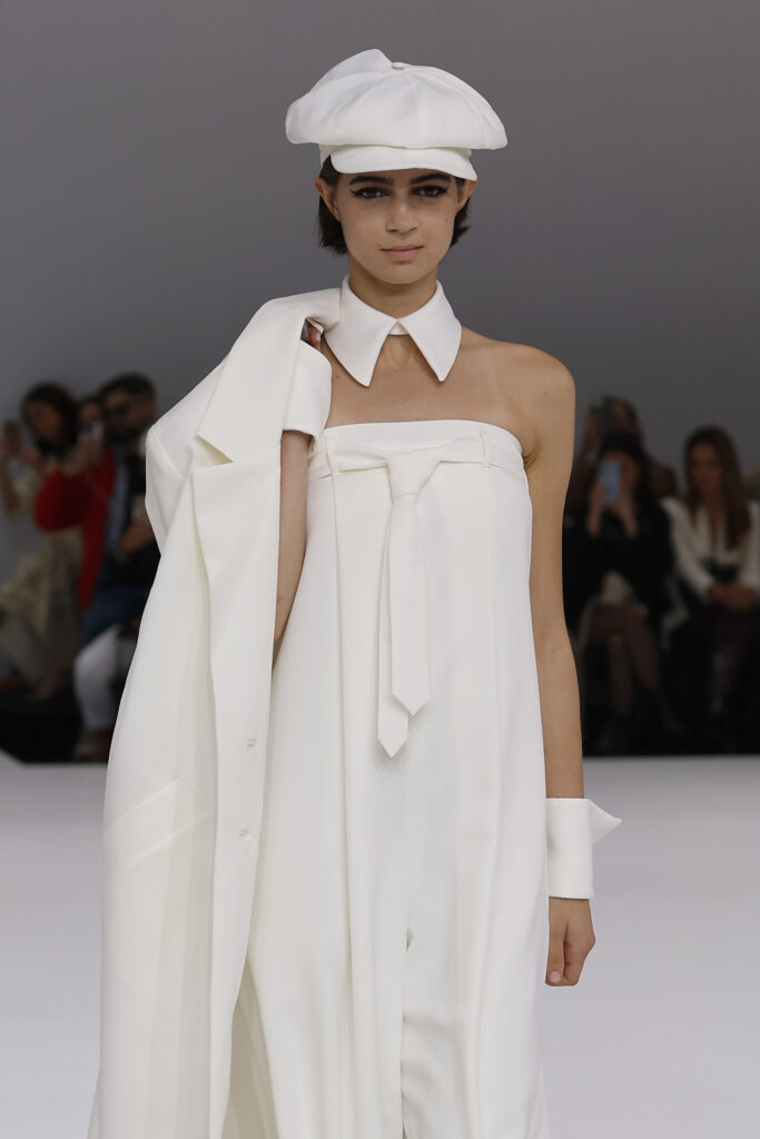 femme dans une combinaison de mariage sur un podium à un défilé