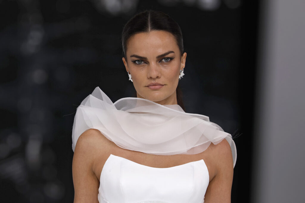 femme dans une robe de mariée à volants sur un podium de défilé