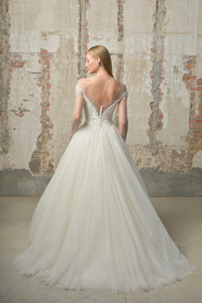 femme dans une robe de mariée princesse brillante à perles et à manches longues effet illusion