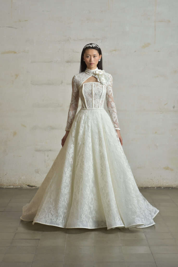 femme en robe de mariée princesse en dentelle de Calais-Caudry avec un col à manche amovible